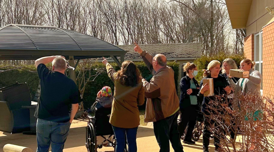 Les patients•es et les membres de l'équipe de Pallia-Vie rassemblés dans le Jardin de Régine pour observer l'éclipse solaire